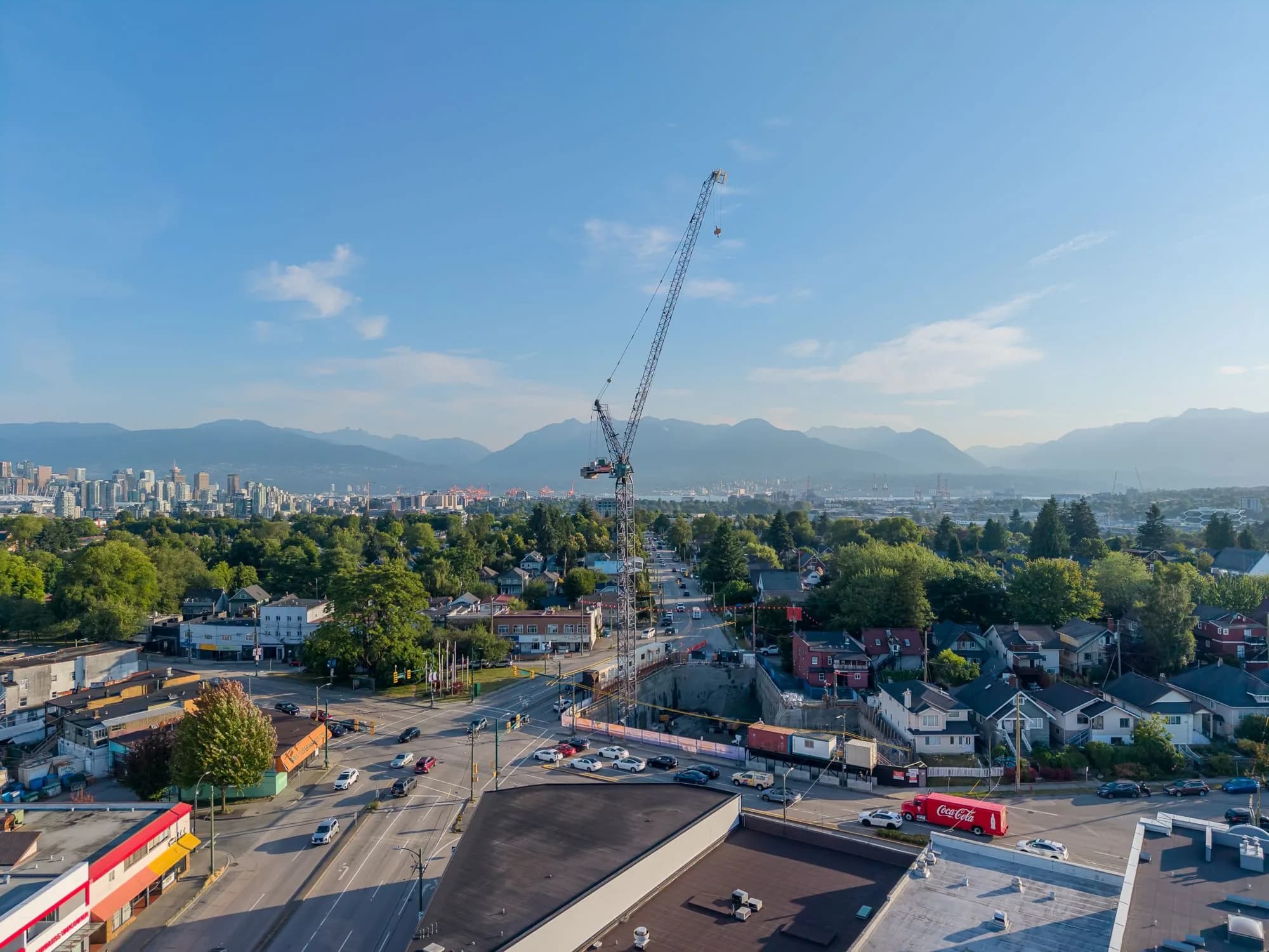 The tower crane at Kingsway and Fraser, with downtown Vancouver and the North Shore mountains behind